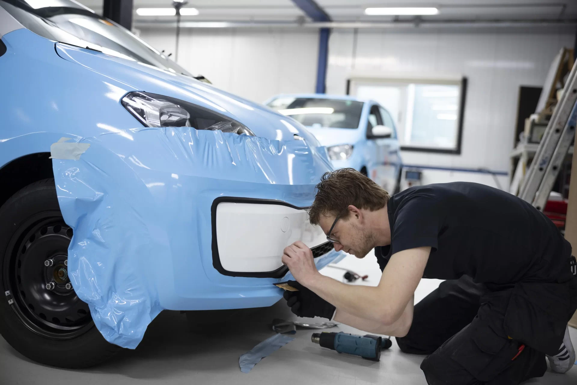 full-shot-man-wrapping-car-indoors_web.webp